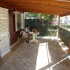 Una veranda coperta con tavolo bianco.