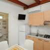 Cucina compatta con bagno visibile a sinistra.