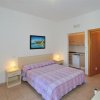 Camera da letto con letto matrimoniale e copriletto a righe.