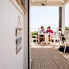 Una coppia seduta a un tavolo all'aperto sul terrazzo di un ristorante, conversando e bevendo.