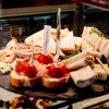 Vassoio di sandwich assortiti e stuzzichini su un piatto elegante.