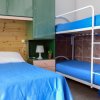Camera con letto singolo e letto a castello, copriletti blu e mobili verdi.