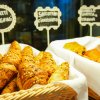 Cesti di croissant integrali e altri dolci con cartelli descrittivi.