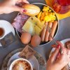 Colazione con uova, salumi, formaggio, caffè, succo e dolci.