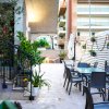 Terrazza esterna con tavoli e sedie, decorata con piante e luci.