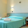 Camera con letto matrimoniale, lenzuola azzurre, telefono e asciugamani.