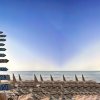 Cartello con indicazioni di località sulla spiaggia.