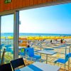 Vista dal bar sulla spiaggia con ombrelloni gialli.