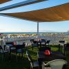 Terrazza con tavolini e vista sul mare.