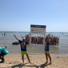 Persone in spiaggia con cornice gigante.
