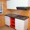 Cucina in legno con frigorifero bianco, fornello a gas e mobili bianchi.