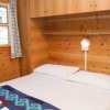 Camera da letto con pareti in legno, letto matrimoniale e finestra con tende a quadretti.