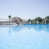 Vista di una grande piscina all'aperto con sedie a sdraio e ombrelloni.