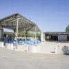 Area con bar all'aperto, sedie blu e tettoia a Due Elle Village & Camping.