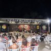 Spettacolo serale all'aperto in campeggio con pubblico seduto.