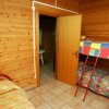 Camera con letti a castello, pareti di legno, porta aperta su un bagno.