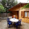 Casa in legno, tavolo rotondo con sedie blu all'aperto.