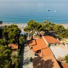 Veduta aerea su case con tetti rossi vicino alla spiaggia.