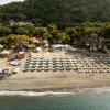 Spiaggia con ombrelloni e lettini, vista dall'alto.