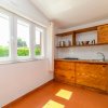 Cucina luminosa con mobili in legno e finestra grande.
