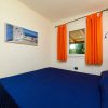 Camera con letto matrimoniale e tende arancioni.