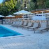 Piscina con sedie a sdraio e gradini in pietra.