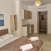 Camera moderna con letto, divano blu e cucina.
