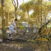 Ragazzo cammina su una rete in un parco avventura.