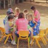 Bambini seduti a tavolino all'aperto per attività.