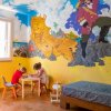 Due bambini disegnano in una stanza con murale di pirata e nave.