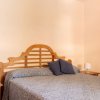 Camera con letto matrimoniale, testiera in legno, due cuscini blu e comodino.