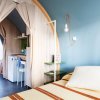 Interno moderno di una cabina con letto, mini-frigo e scaffali, decorato con toni chiari.
