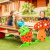 Bambini seduti a un tavolo da picnic con decorazioni di fragole e funghi in un parco giochi.