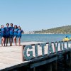 Gruppo sul molo con sfondo mare e scritta 