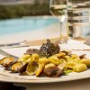 Piatto di gnocchi con vongole, servito vicino a una piscina.