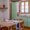 Cucina con tavolo e sedie in legno chiaro.