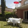 Giardino con tavolo apparecchiato e ombrellone rosso.