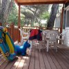 Veranda in legno con tavolo e sedie di plastica.