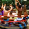 Bambini su giostra rossa in un parco giochi.