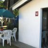 Bungalow bianco con sedie e tavolo fuori.