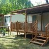 Due case mobili con verande in legno in un'area verde.