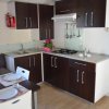 Cucina moderna con mobili scuri, piano cottura, lavello e tavolo da pranzo apparecchiato.