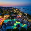Piscina notturna illuminata con vista mare.