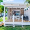 Veranda di una casa mobile bianca con tavolo e sedie.