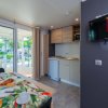 Cucina con tavolo apparecchiato e accesso alla veranda.