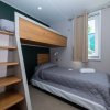 Cameretta con letto a castello e scale in legno.
