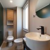 Bagno moderno con lavabo rotondo e specchio.