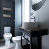 Bagno con lavabo su mobile nero e wc.