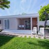 Bungalow moderno con veranda, sedie e tavolo.