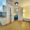 Un appartamento con cucina moderna, pavimento in legno e due stanze arredate.